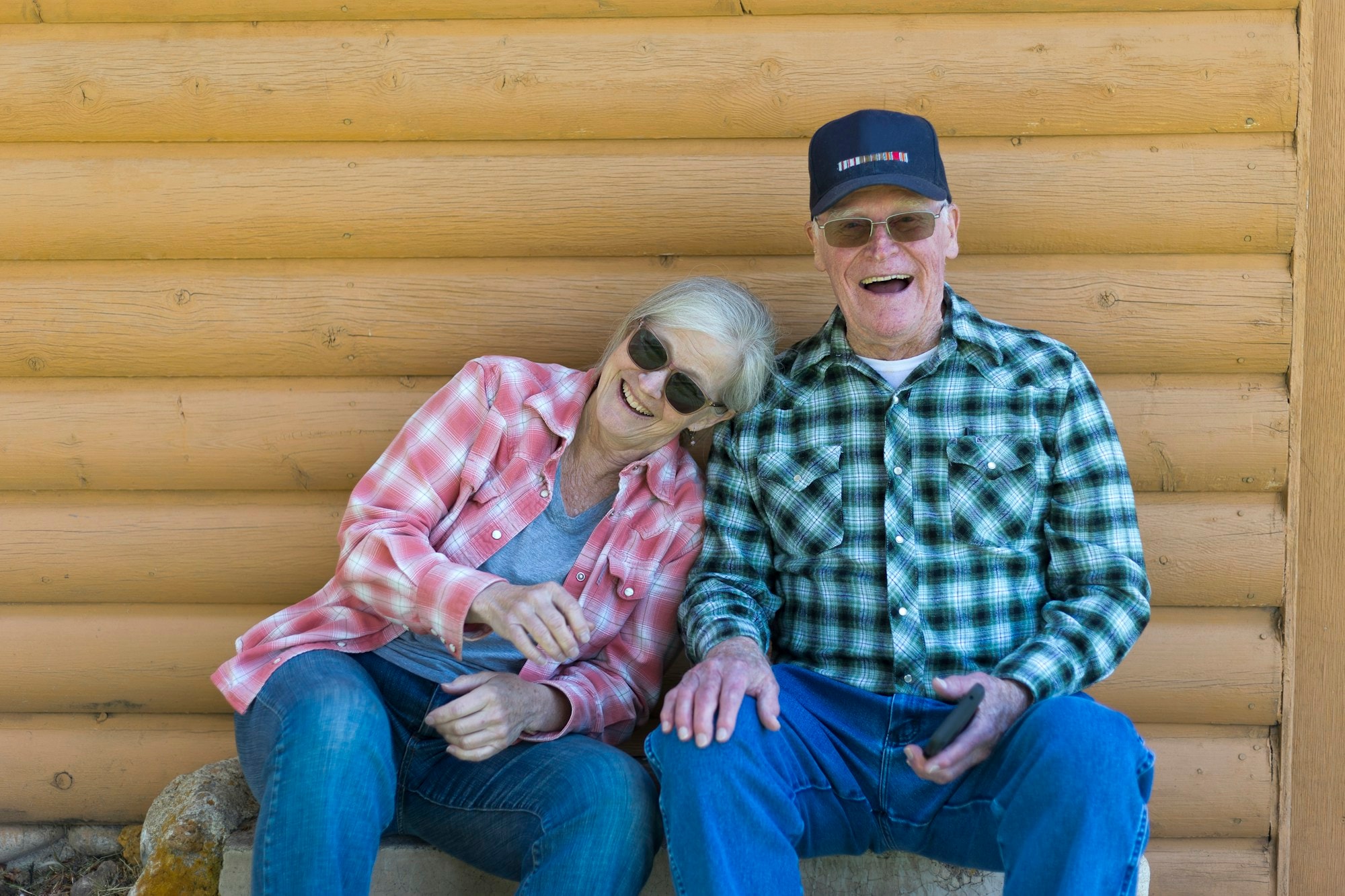 A senior couple laughing together while sitting outdoors